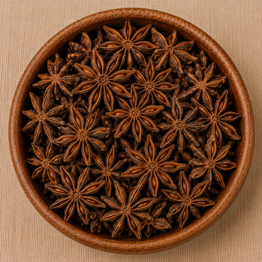 Whole dried star anise spices filling a round wooden bowl, viewed from above on a beige surface
