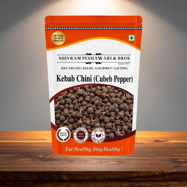 Kebab Chini Cubeb Pepper orange resealable pouch displayed on a rustic wooden surface with studio lighting