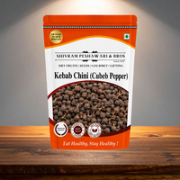 Kebab Chini Cubeb Pepper orange resealable pouch displayed on a rustic wooden surface with studio lighting